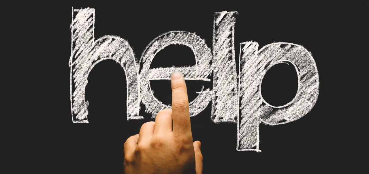 Eine Hand, deren Finger auf den Schriftzug Help tippen.